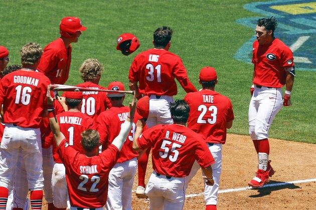 Georgia's Cam Shepherd (7) is welcomed home by teammates after hitting a walk off two run home run against Texas A&M during the ninth inning of the Southeastern Conference tournament NCAA college baseball game, Wednesday, May 22, 2019, in Hoover, Ala. Georgia defeated Texas A&M 2-0.(AP Photo/Butch Dill)