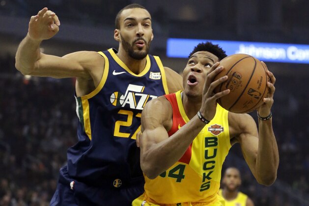 Milwaukee Bucks' Giannis Antetokounmpo, right, shoots past Utah Jazz's Rudy Gobert during the first half of an NBA basketball game Monday, Jan. 7, 2019, in Milwaukee. (AP Photo/Aaron Gash)