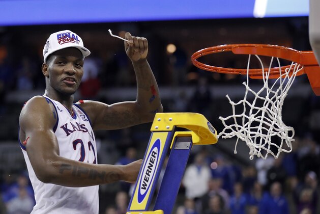 Kansas' Silvio De Sousa celebrates by cutting down the net after defeating Duke in a regional final game in the NCAA men's college basketball tournament Sunday, March 25, 2018, in Omaha, Neb. Kansas won 85-81 in overtime. (AP Photo/Charlie Neibergall)