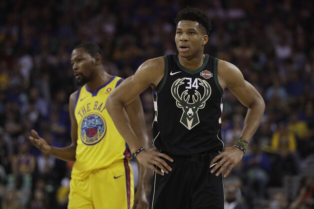 Milwaukee Bucks' Giannis Antetokounmpo (34) stands in front of Golden State Warriors' Kevin Durant during the first half of an NBA basketball game Thursday, March 29, 2018, in Oakland, Calif. (AP Photo/Marcio Jose Sanchez)