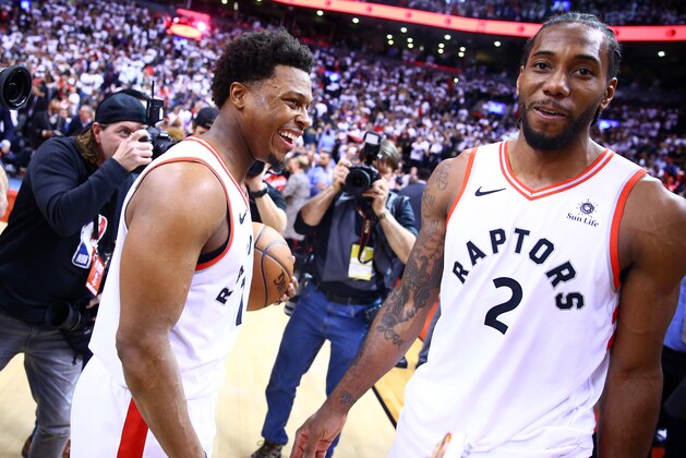 TORONTO, ON - MAY 12:  Kawhi Leonard #2 (R) of the Toronto Raptors speaks with Kyle Lowry #7 after sinking a buzzer beater to win Game Seven of the second round of the 2019 NBA Playoffs against the Philadelphia 76ers at Scotiabank Arena on May 12, 2019 in Toronto, Canada.  NOTE TO USER: User expressly acknowledges and agrees that, by downloading and or using this photograph, User is consenting to the terms and conditions of the Getty Images License Agreement.  (Photo by Vaughn Ridley/Getty Images)