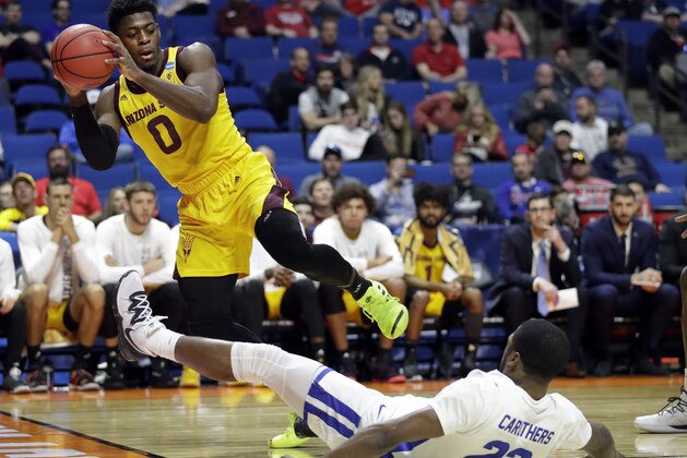 Arizona State's Luguentz Dort (0) grabs a ball before it goes out of bounds after colliding with Buffalo's Dontay Caruthers (22) during the second half of a first round men's college basketball game in the NCAA Tournament Friday, March 22, 2019, in Tulsa, Okla. (AP Photo/Jeff Roberson)