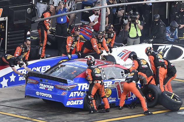 Crew members lift Martin Truex Jr.'s car to change a flat tire during a NASCAR Cup Series auto race at Charlotte Motor Speedway in Concord, N.C., Sunday, May 26, 2019. (AP Photo/Mike McCarn)