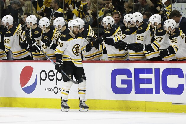 Boston Bruins' David Pastrnak (88) is congratulated by teammates following Pastrnak's goal against the Carolina Hurricanes during the second period in Game 4 of the NHL hockey Stanley Cup Eastern Conference final series in Raleigh, N.C., Thursday, May 16, 2019. (AP Photo/Gerry Broome)