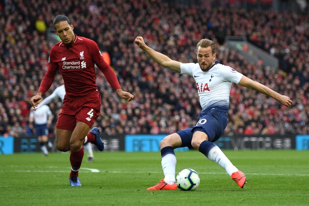 LIVERPOOL, ENGLAND - MARCH 31:  Harry Kane of Tottenham Hotspur shoots under pressure from Virgil Van Dijk of Liverpool during the Premier League match between Liverpool FC and Tottenham Hotspur at Anfield on March 31, 2019 in Liverpool, United Kingdom. (Photo by Shaun Botterill/Getty Images)