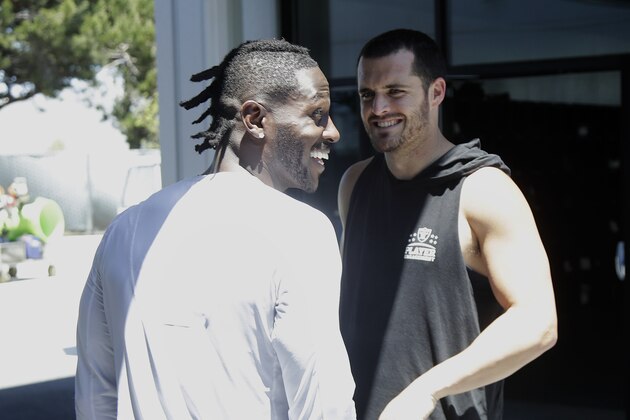 Oakland Raiders wide receiver Antonio Brown, left, speaks with quarterback Derek Carr after an official team activity at the NFL football team's headquarters in Alameda, Calif., Tuesday, May 28, 2019. (AP Photo/Jeff Chiu)