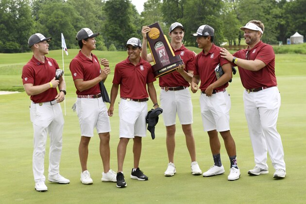 Stanford's David Snyder, from left, Daulet Tuleubayev, Nate Menon, Henry Shimp, Isaiah Salinda and coach Ray Conrad celebrate with the national championship trophy after beating Texas in the NCAA men's college golf tournament Wednesday, May 29, 2019, in Fayetteville, Ark. (AP Photo/Michael Woods)