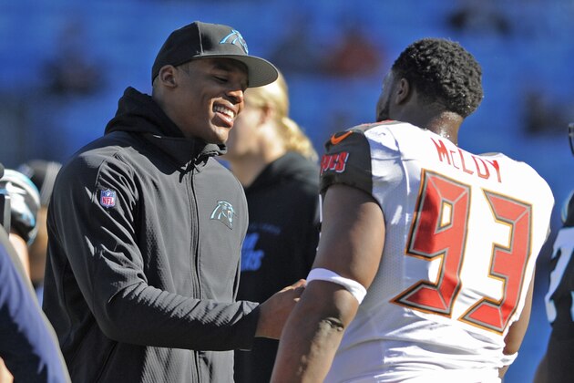 Carolina Panthers' Cam Newton, left, greets Tampa Bay Buccaneers' Gerald McCoy, right, before an NFL football game in Charlotte, N.C., Sunday, Dec. 14, 2014. Newton will not play in the game after being injured in a car accident on Tuesday. (AP Photo/Mike McCarn)