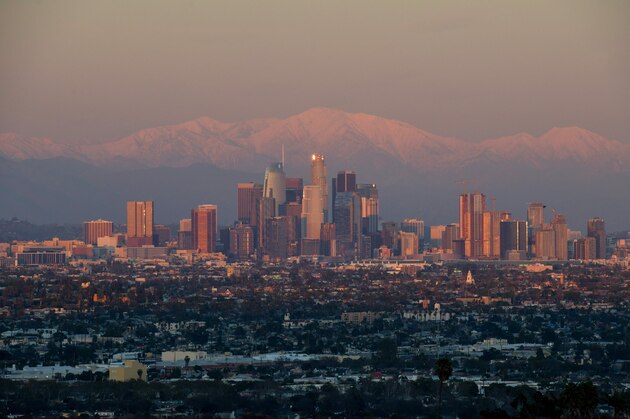 This photo shows a view of the downtown Los Angeles skyline with the snow-covered San Gabriel Mountains in the background as the sun sets on February 7, 2019. (Photo by Chris Delmas / AFP)        (Photo credit should read CHRIS DELMAS/AFP/Getty Images)