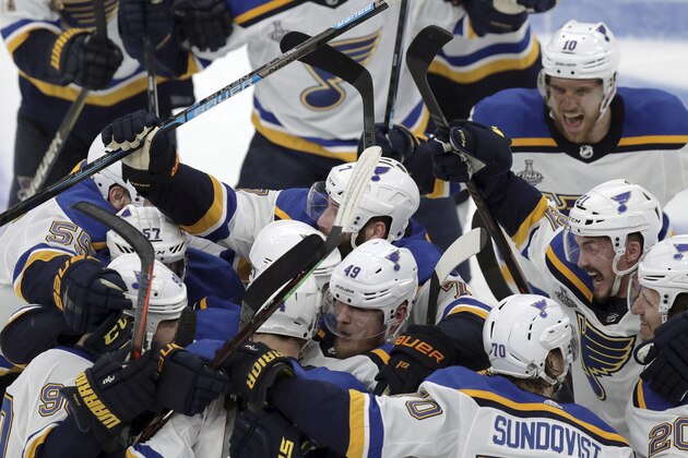 CORRECTS SOURCE AND PHOTOGRAPHER'S NAME - St. Louis Blues teammates mob Carl Gunnarsson, who scored the winning goal against the Boston Bruins during the first overtime period in Game 2 of the NHL hockey Stanley Cup Final, Wednesday, May 29, 2019, in Boston. (AP Photo/Charles Krupa)