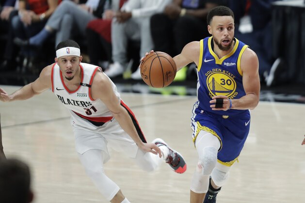 Golden State Warriors guard Stephen Curry, right, drives with the ball as his brother, Portland Trail Blazers guard Seth Curry, left, watches during the second half of Game 3 of the NBA basketball playoffs Western Conference finals Saturday, May 18, 2019, in Portland, Ore. The Warriors won 110-99. (AP Photo/Ted S. Warren)