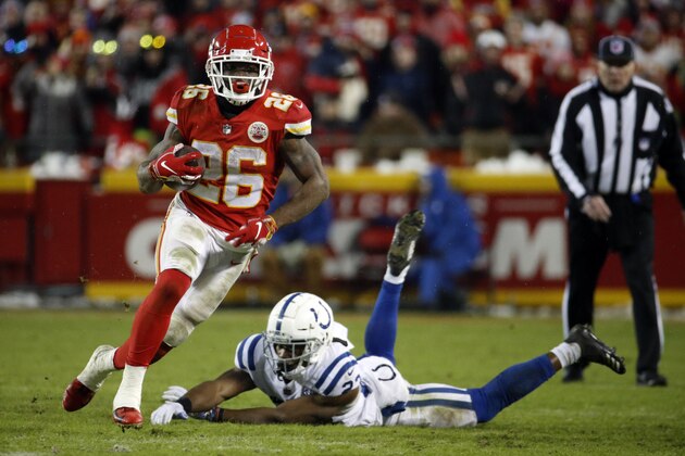 Kansas City Chiefs running back Damien Williams (26) runs past Indianapolis Colts cornerback Kenny Moore (23) during the second half of an NFL divisional football playoff game in Kansas City, Mo., Saturday, Jan. 12, 2019. (AP Photo/Charlie Riedel)