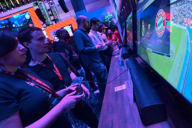 Gaming fans sample EA Sports FIFA 18 as Bayern Munich play Real Madrid on the screen at the Los Angeles Convention Center on day one of E3 2017, the three day Electronic Entertainment Expo, one of the biggest events in the gaming industry calendar, on June 13, 2017 in Los Angeles, California. / AFP PHOTO / FREDERIC J. BROWN        (Photo credit should read FREDERIC J. BROWN/AFP/Getty Images)