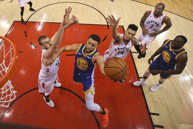 Golden State Warriors' Stephen Curry (30) drives to the basket between Toronto Raptors' Marc Gasol, left, and Danny Green (14) during Game 1 of basketball’s NBA Finals, Thursday, May 30, 2019, in Toronto. (Gregory Shamus/Pool Photo via AP)