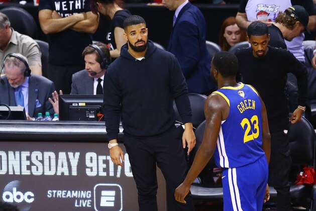 TORONTO, ONTARIO - JUNE 02:  Drake and Draymond Green #23 of the Golden State Warriors exchange words during Game Two of the 2019 NBA Finals at Scotiabank Arena between the Golden State Warriors and the Toronto Raptors on June 02, 2019 in Toronto, Canada.  NOTE TO USER: User expressly acknowledges and agrees that, by downloading and or using this photograph, User is consenting to the terms and conditions of the Getty Images License Agreement. (Photo by Vaughn Ridley/Getty Images)