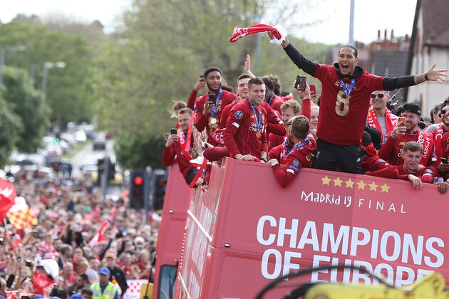 LIVERPOOL, ENGLAND - JUNE 02: James Milner and Virgil van Dijk of Liverpool with the UEFA Champions League trophy on board a parade bus after winning the UEFA Champions League final against Tottenham Hotspur in Madrid on June 2, 2019 in Liverpool, England. (Photo by Nigel Roddis/Getty Images)
