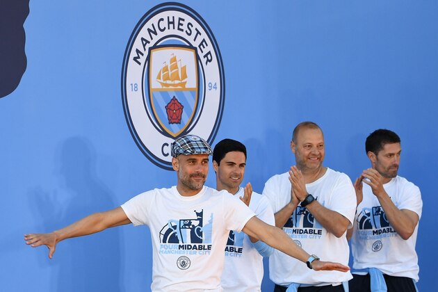 Manchester City's Spanish manager Pep Guardiola (L) takes part in a stage presentation following an open-top bus parade through Manchester, northern England on May 20, 2019, to celebrate winning the 2019 Premier League title, the FA Cup and English League Cup. - Pep Guardiola saluted Manchester City's history makers after they clinched the domestic treble with a swaggering 6-0 rout of Watford in the FA Cup final on Saturday. Just a week after winning a second successive Premier League crown, City's record-equalling FA Cup final victory made them the first English club to win the English title, FA Cup and League Cup in the same season. (Photo by Paul ELLIS / AFP)        (Photo credit should read PAUL ELLIS/AFP/Getty Images)