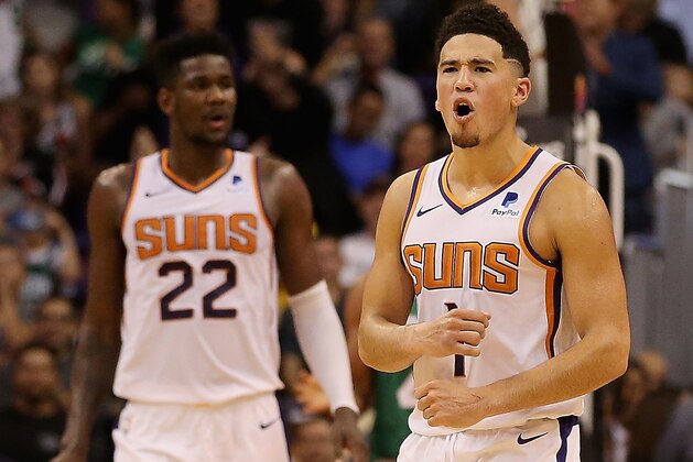 PHOENIX, AZ - NOVEMBER 08:  Devin Booker #1 of the Phoenix Suns reacts alongside Deandre Ayton #22 during the NBA game against the Boston Celtics at Talking Stick Resort Arena on November 8, 2018 in Phoenix, Arizona. The Celtics defeated the Suns 116-109 in overtime.  NOTE TO USER: User expressly acknowledges and agrees that, by downloading and or using this photograph, User is consenting to the terms and conditions of the Getty Images License Agreement.  (Photo by Christian Petersen/Getty Images)