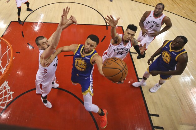 Golden State Warriors' Stephen Curry (30) drives to the basket between Toronto Raptors' Marc Gasol, left, and Danny Green (14) during Game 1 of basketball’s NBA Finals, Thursday, May 30, 2019, in Toronto. (Gregory Shamus/Pool Photo via AP)