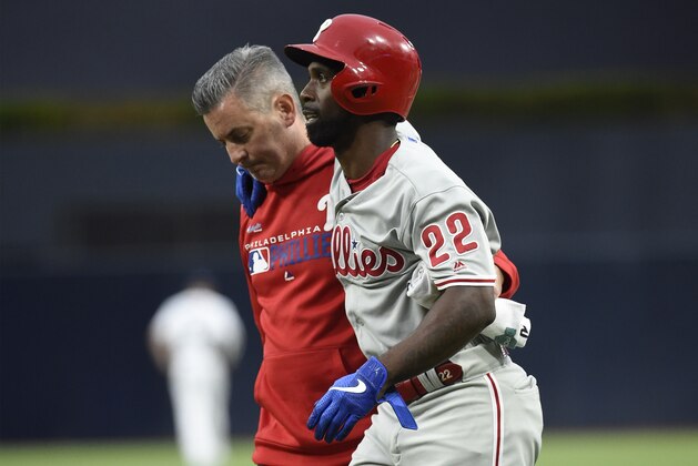 SAN DIEGO, CA - JUNE 3: Andrew McCutchen #22 of the Philadelphia Phillies is helped off the field by a trainer during the first inning of a baseball game against the San Diego Padres at Petco Park June 3, 2019 in San Diego, California.  (Photo by Denis Poroy/Getty Images)