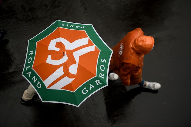 People hold their umbrella as rain falls on day eleven of The Roland Garros 2019 French Open tennis tournament in Paris on June 5, 2019. (Photo by CHRISTOPHE ARCHAMBAULT / AFP)        (Photo credit should read CHRISTOPHE ARCHAMBAULT/AFP/Getty Images)