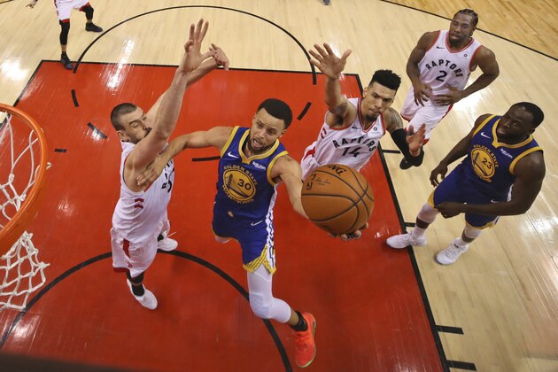 Golden State Warriors' Stephen Curry (30) drives to the basket between Toronto Raptors' Marc Gasol, left, and Danny Green (14) during Game 1 of basketball’s NBA Finals, Thursday, May 30, 2019, in Toronto. (Gregory Shamus/Pool Photo via AP)