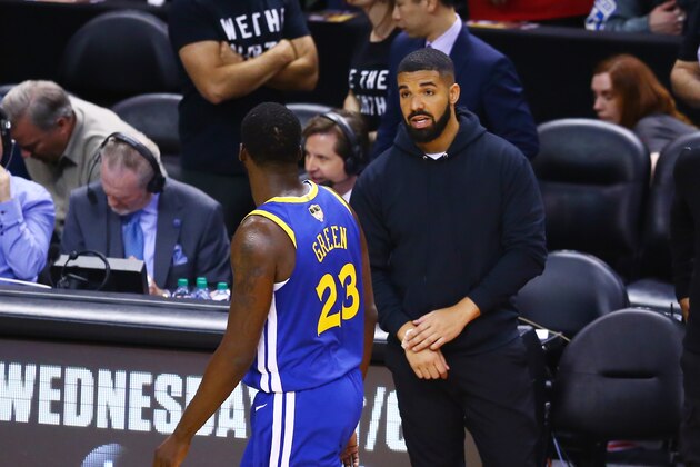 TORONTO, ONTARIO - JUNE 02:  Drake and Draymond Green #23 of the Golden State Warriors exchange words during Game Two of the 2019 NBA Finals at Scotiabank Arena between the Golden State Warriors and the Toronto Raptors on June 02, 2019 in Toronto, Canada.  NOTE TO USER: User expressly acknowledges and agrees that, by downloading and or using this photograph, User is consenting to the terms and conditions of the Getty Images License Agreement. (Photo by Vaughn Ridley/Getty Images)