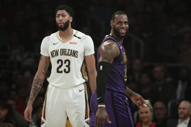 Los Angeles Lakers' LeBron James, right, smiles as he walks past New Orleans Pelicans' Anthony Davis during the first half of an NBA basketball game Friday, Dec. 21, 2018, in Los Angeles. (AP Photo/Jae C. Hong)