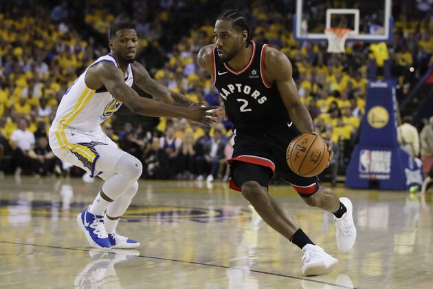 Toronto Raptors forward Kawhi Leonard (2) dribbles against Golden State Warriors forward Alfonzo McKinnie during the first half of Game 3 of basketball's NBA Finals in Oakland, Calif., Wednesday, June 5, 2019. (AP Photo/Ben Margot)