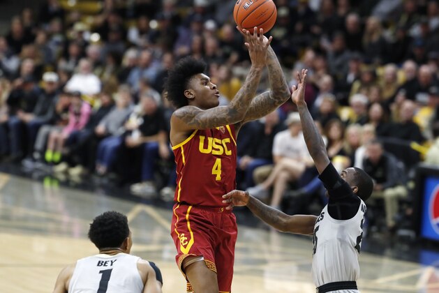 USC guard Kevin Porter Jr., center, goes up for a basket between Colorado guards Tyler Bey, left, and McKinley Wright IV during the first half of an NCAA college basketball game Saturday, March 9, 2019, in Boulder, Colo. (AP Photo/David Zalubowski)