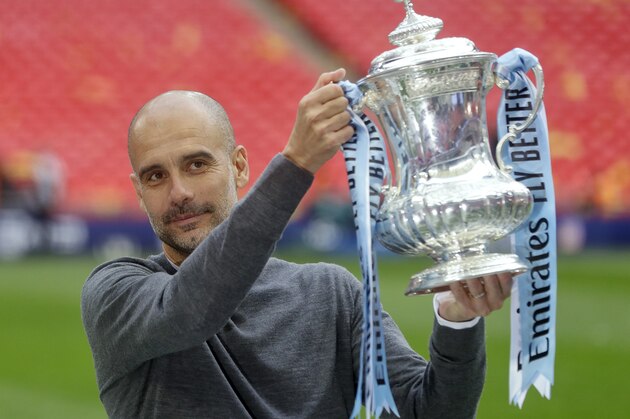Manchester City's manager Pep Guardiola poses with the trophy after the English FA Cup Final soccer match between Manchester City and Watford at Wembley stadium in London, Saturday, May 18, 2019. (AP Photo/Kirsty Wigglesworth)