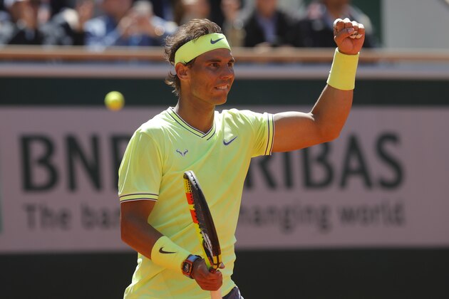 Spain's Rafael Nadal celebrates winning after Switzerland's Roger Federer's ball went out, rear left, during their semifinal match of the French Open tennis tournament at the Roland Garros stadium in Paris, Friday, June 7, 2019. (AP Photo/Michel Euler)