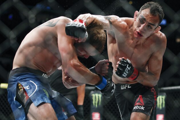 Tony Ferguson, right, punches Donald Cerrone, left, during their lightweight mixed martial arts bout at UFC 238, Saturday, June 8, 2019, in Chicago. (AP Photo/Kamil Krzaczynski)