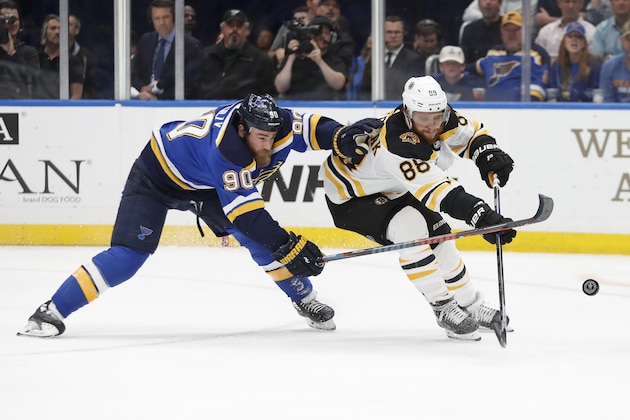 St. Louis Blues center Ryan O'Reilly (90) and Boston Bruins right wing David Pastrnak (88), of the Czech Republic, battle for the puck during the second period of Game 4 of the NHL hockey Stanley Cup Final Monday, June 3, 2019, in St. Louis. (AP Photo/Jeff Roberson)