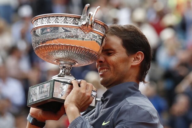 Spain's Rafael Nadal lifts the trophy as he celebrates his record 12th French Open tennis tournament title after winning his men's final match against Austria's Dominic Thiem in four sets, 6-3, 5-7, 6-1, 6-1, at the Roland Garros stadium in Paris, Sunday, June 9, 2019. (AP Photo/Christophe Ena)