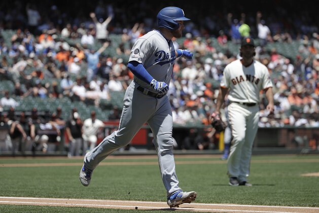 Los Angeles Dodgers' Max Muncy, left, gestures while running up the during the first inning of line after hitting a solo home run off of San Francisco Giants pitcher Madison Bumgarner, right, during the first inning of a baseball game in San Francisco, Sunday, June 9, 2019. (AP Photo/Jeff Chiu)