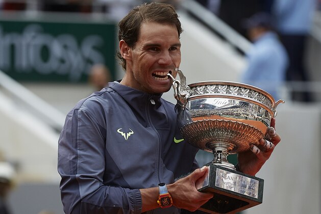 PARIS, FRANCE - JUNE 09: Rafael Nadal of Spain bites the trophy after defeating Dominic Thiem of Austria in the final during Day Fifteen of the 2019 French Open at Roland Garros on June 09, 2019 in Paris, France.(Photo by Quality Sport Images/Getty Images)