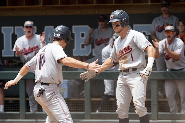 Auburn's Edouard Julien (10) celebrates with Judd Ward (1) after scoring a run during the first inning of an NCAA super regional baseball game against North Carolina in Chapel Hill, N.C., Monday, June 10, 2019. (AP Photo/Ben McKeown)