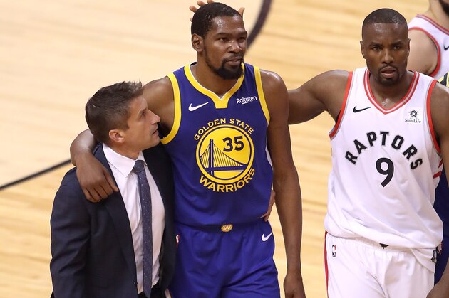 TORONTO, ONTARIO - JUNE 10:  Kevin Durant #35 of the Golden State Warriors is consoled by Serge Ibaka #9 of the Toronto Raptors after sustaining an injury in the first half during Game Five of the 2019 NBA Finals at Scotiabank Arena on June 10, 2019 in Toronto, Canada. NOTE TO USER: User expressly acknowledges and agrees that, by downloading and or using this photograph, User is consenting to the terms and conditions of the Getty Images License Agreement. (Photo by Claus Andersen/Getty Images)