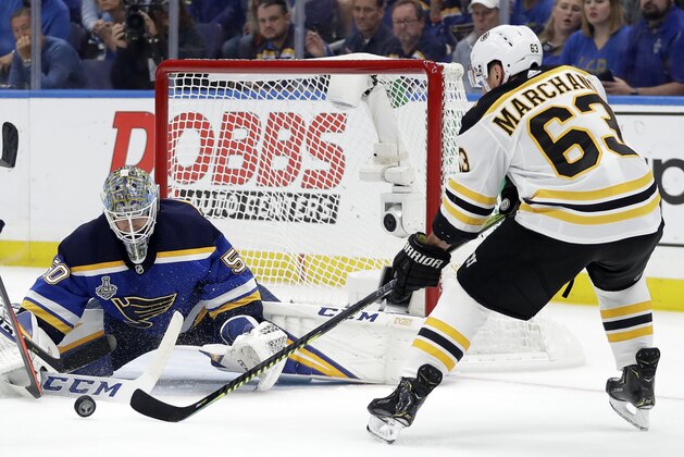 Boston Bruins left wing Brad Marchand (63) reaches for a rebound in front of St. Louis Blues goaltender Jordan Binnington (50) during the first period of Game 6 of the NHL hockey Stanley Cup Final Sunday, June 9, 2019, in St. Louis. (AP Photo/Jeff Roberson)
