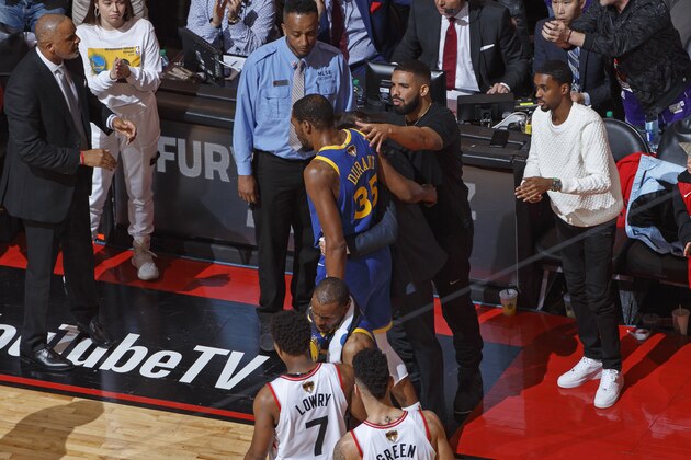 TORONTO, CANADA - JUNE 10: Rapper, Drake talks to Kevin Durant #35 of the Golden State Warriors after sustaining an injury during Game Five of the NBA Finals against the Toronto Raptors on June 10, 2019 at Scotiabank Arena in Toronto, Ontario, Canada. NOTE TO USER: User expressly acknowledges and agrees that, by downloading and/or using this photograph, user is consenting to the terms and conditions of the Getty Images License Agreement. Mandatory Copyright Notice: Copyright 2019 NBAE (Photo by Mark Blinch/NBAE via Getty Images)