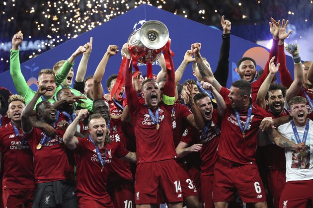 Liverpool's Jordan Henderson lifts the trophy to celebrate with his teammates winning the Champions League final soccer match between Tottenham Hotspur and Liverpool at the Wanda Metropolitano Stadium in Madrid, Saturday, June 1, 2019. (AP Photo/Francisco Seco)