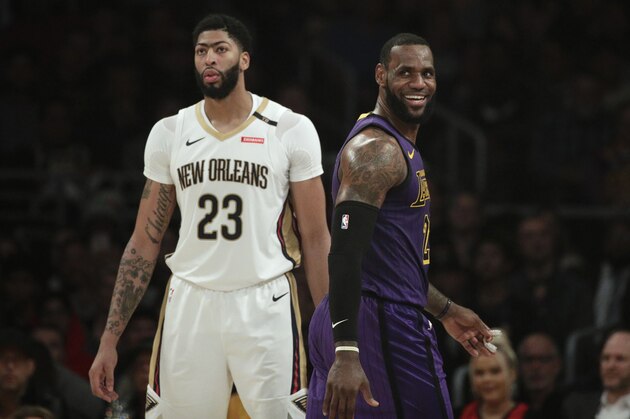Los Angeles Lakers' LeBron James, right, smiles as he walks past New Orleans Pelicans' Anthony Davis during the first half of an NBA basketball game Friday, Dec. 21, 2018, in Los Angeles. (AP Photo/Jae C. Hong)