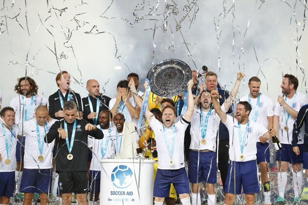 MANCHESTER, ENGLAND - JUNE 10: Robbie Williams and Olly Murs lift the trophy after winning the Soccer Aid for UNICEF 2018 match between England and The Rest of the World at Old Trafford on June 10, 2018 in Manchester, England. (Photo by Lynne Cameron/Getty Images)