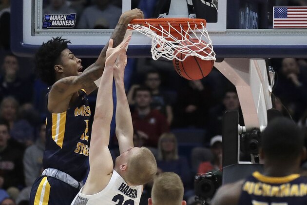 Murray State's Ja Morant, left, dunks over Marquette's Joey Hauser (22) during the second half of a first round men's college basketball game in the NCAA Tournament, Thursday, March 21, 2019, in Hartford, Conn. (AP Photo/Elise Amendola)