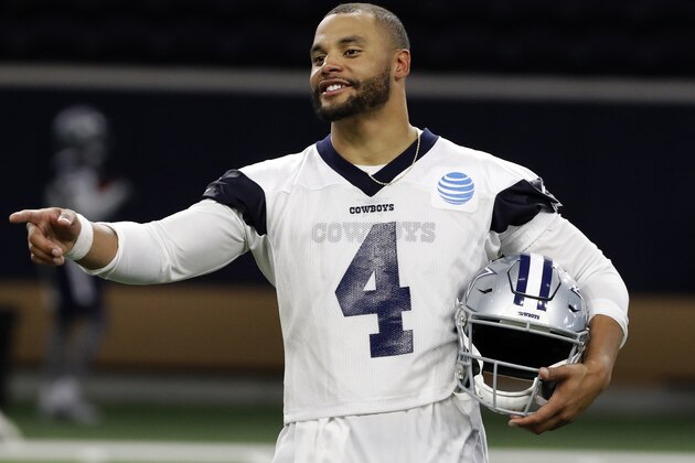 Dallas Cowboys quarterback Dak Prescott (4) talks to a teammate as he participates in drills at the team's NFL football training facility in Frisco, Texas, Tuesday, June 11, 2019. (AP Photo/Tony Gutierrez