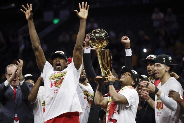 Toronto Raptors center Serge Ibaka, left, guard Kyle Lowry, center, and guard Danny Green celebrate with teammates after the Raptors defeated the Golden State Warriors in Game 6 of basketball's NBA Finals in Oakland, Calif., Thursday, June 13, 2019. (AP Photo/Ben Margot)