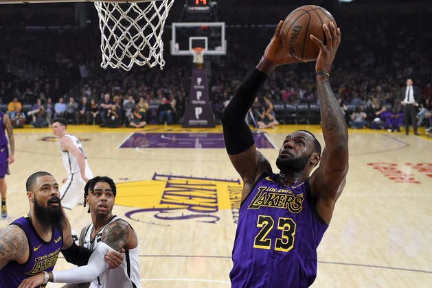 Los Angeles Lakers forward LeBron James, right, shoots as center Tyson Chandler, left, and Brooklyn Nets guard D'Angelo Russell watch during the first half of an NBA basketball game Friday, March 22, 2019, in Los Angeles. (AP Photo/Mark J. Terrill)