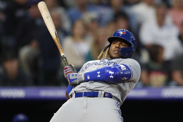 Toronto Blue Jays' Vladimir Guerrero Jr. leans back to avoid an inside pitch from Colorado Rockies starting pitcher German Marquez in the fifth inning of a baseball game Friday, May 31, 2019, in Denver. (AP Photo/David Zalubowski)