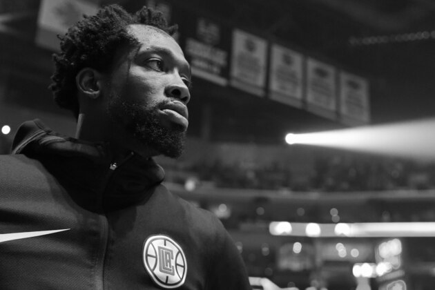 LOS ANGELES, CA - APRIL 26: Patrick Beverley #21 of the LA Clippers stands for the National Anthem before Game Six of Round One against the Golden State Warriors during the 2019 NBA Playoffs on April 26, 2019 at STAPLES Center in Los Angeles, California. NOTE TO USER: User expressly acknowledges and agrees that, by downloading and/or using this photograph, user is consenting to the terms and conditions of the Getty Images License Agreement. Mandatory Copyright Notice: Copyright 2019 NBAE (Photo by Andrew D. Bernstein/NBAE via Getty Images)(EDITORS NOTE this image has been converted to black and white)